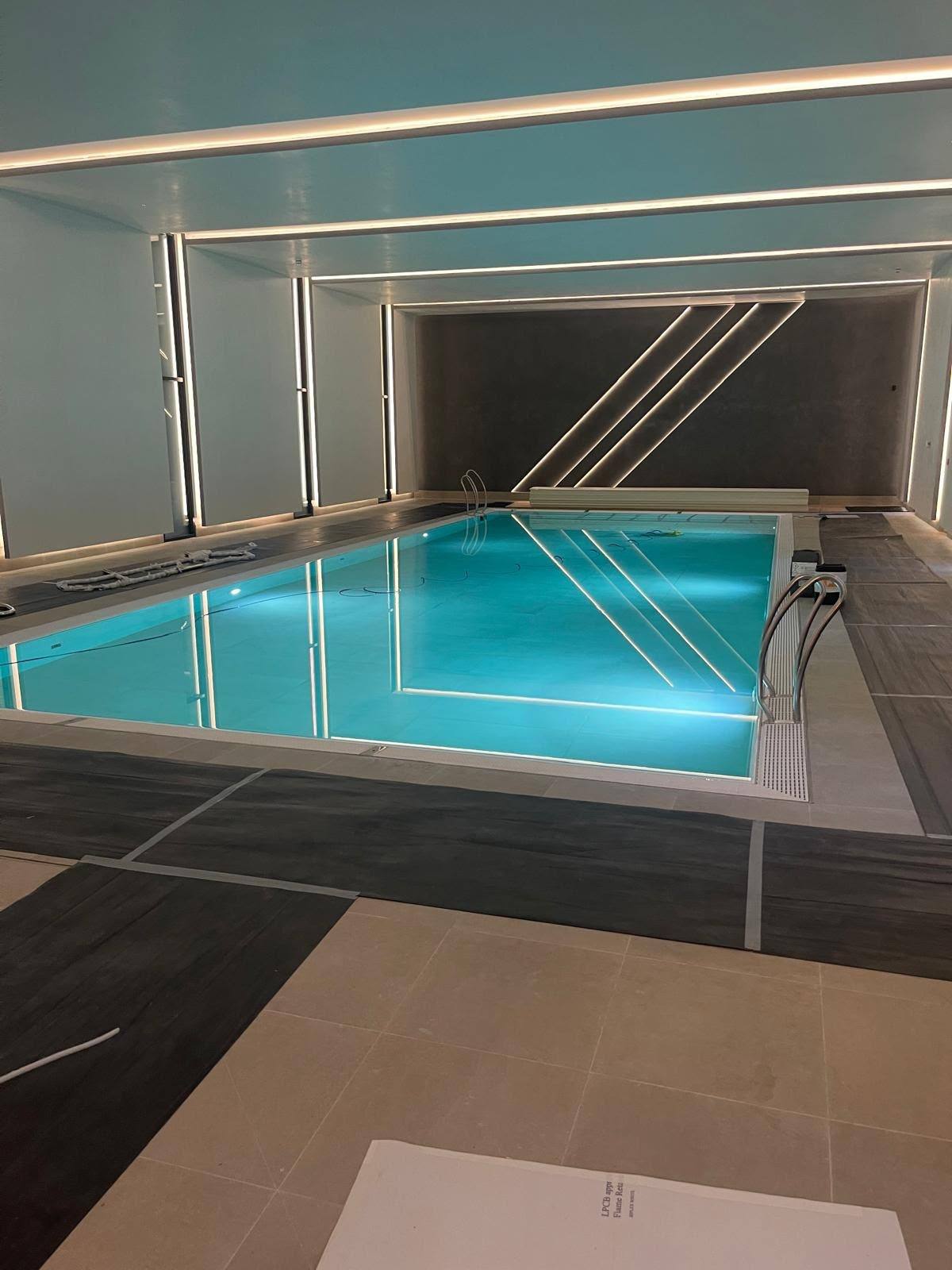 Large indoor swimming pool with sealed movement joints and stone surround