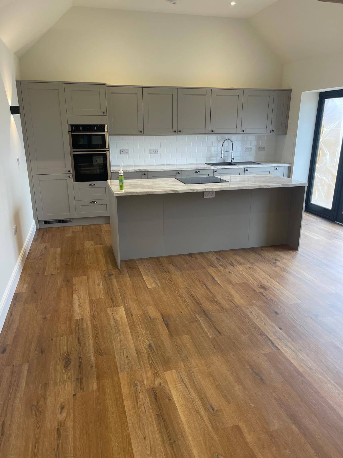 Grey kitchen with marble island worktop joints sealed throughout