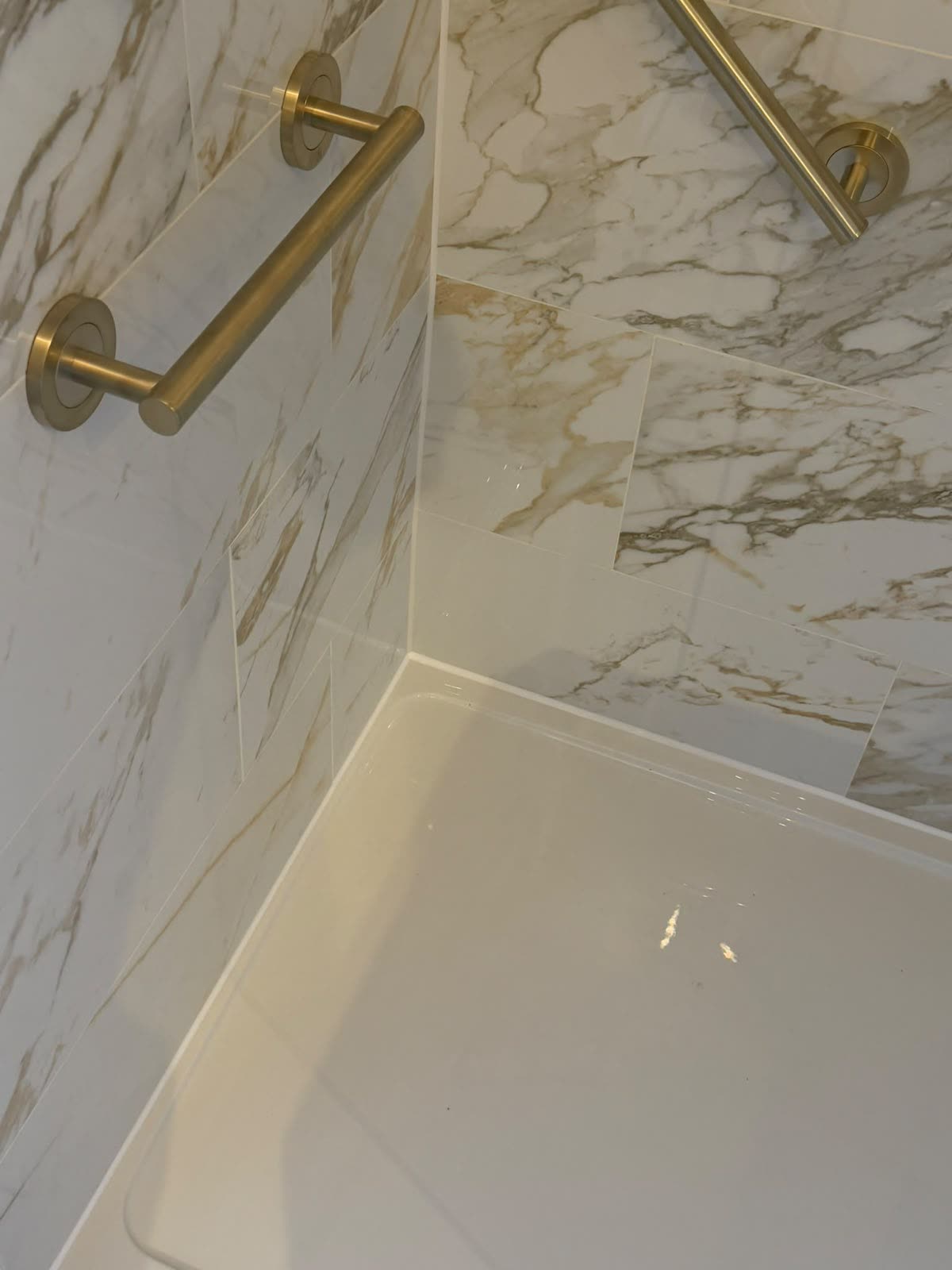 Freshly applied silicone bead tooled to a straight line around a shower tray corner