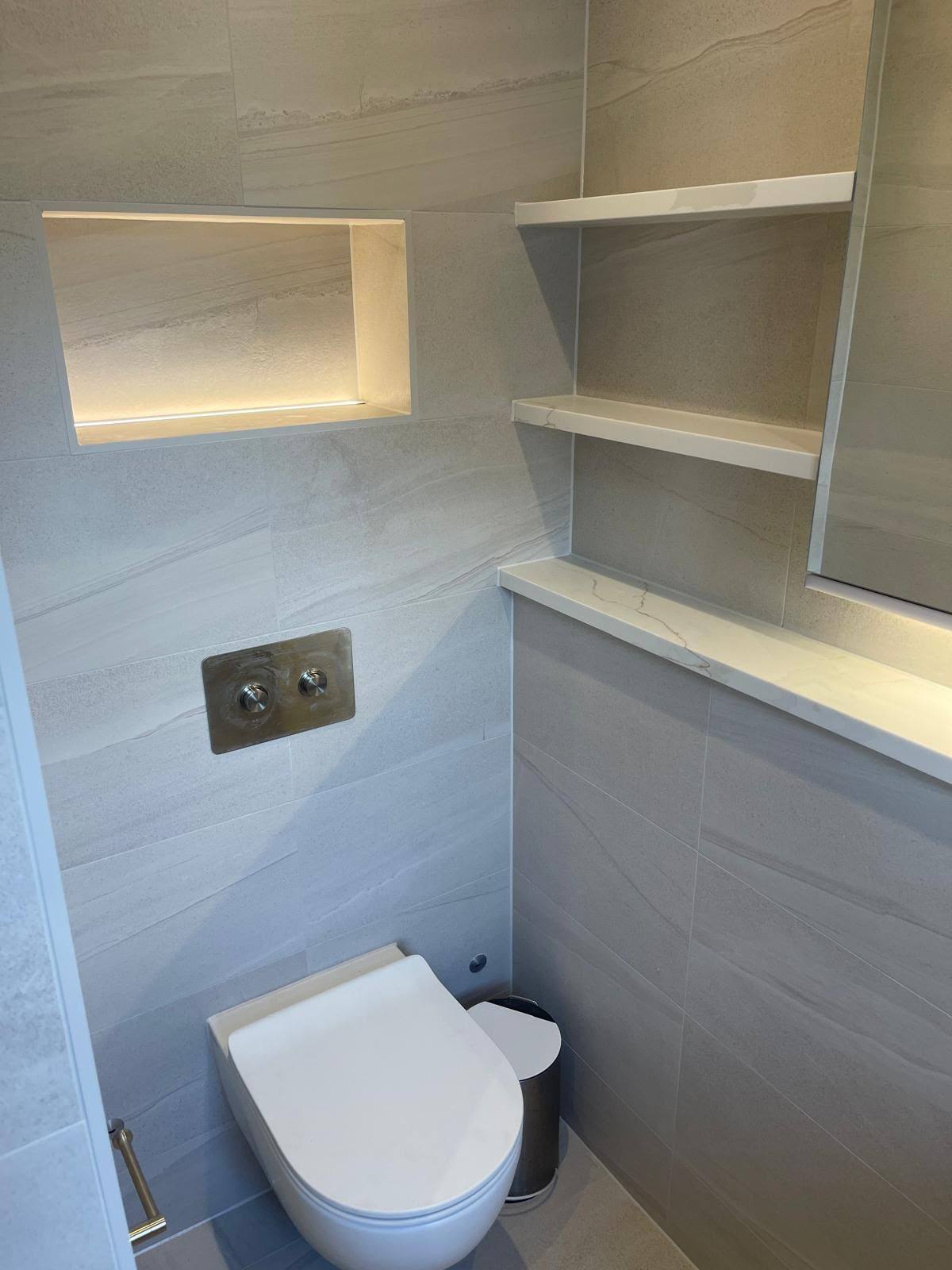 Marble-effect niche shelf above a wall-hung WC with sealed joints