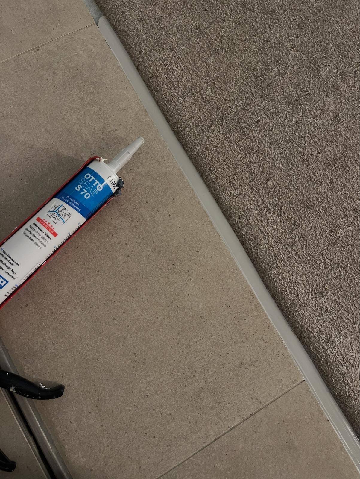 Neutral-cure silicone mastic applied to a stone tile floor joint