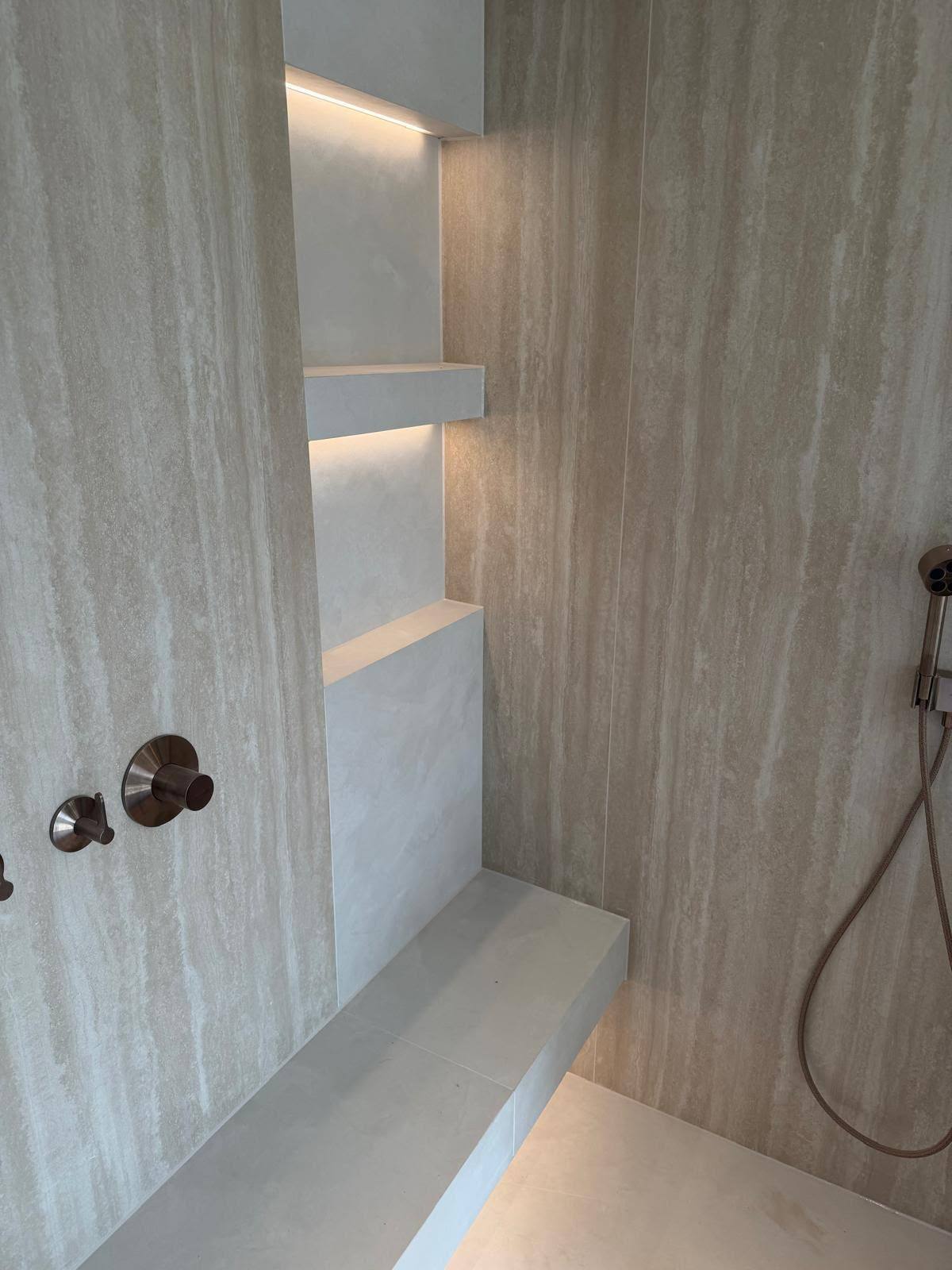 Stone wet room shelving with sealed joints and rose gold fittings